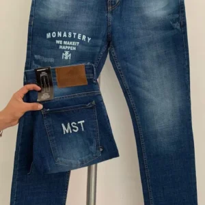 Jean Premium de alta calidad para hombre, corte moderno, color azul medio con sublimado Monastery en pierna derecha, bordados en el monedero y en bolsillo trasero