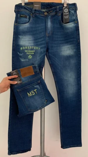 Jean Premium de alta calidad para hombre, corte moderno, color azul medio con sublimado Monastery en pierna derecha, bordados en el monedero y en bolsillo trasero