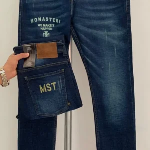 Jean Premium de alta calidad para hombre, corte moderno, color azul medio con sublimado Monastery en pierna derecha, bordados en el monedero y en bolsillo trasero