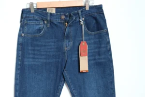 Jean Premium de alta calidad para hombre, corte moderno, color azul medio clásico con bigotes, pines y botón contramarcado