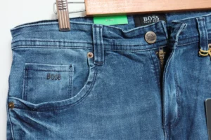 Jean Premium de alta calidad para hombre, corte moderno, color azul medio con desgastes, nips, monedero y bolsillo trasero bordado, pines y botón contramarcado